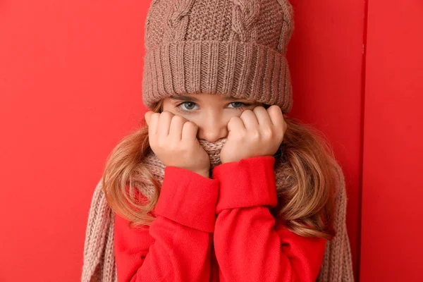 Little girl in winter clothes on color background — Stock Photo, Image