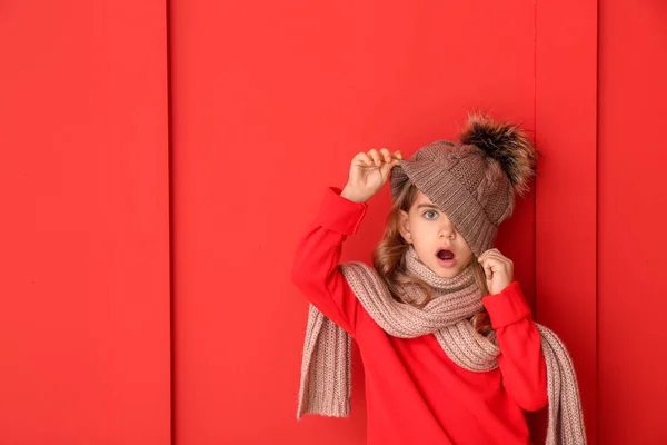 Menina surpreendida em roupas de inverno no fundo de cor — Fotografia de Stock