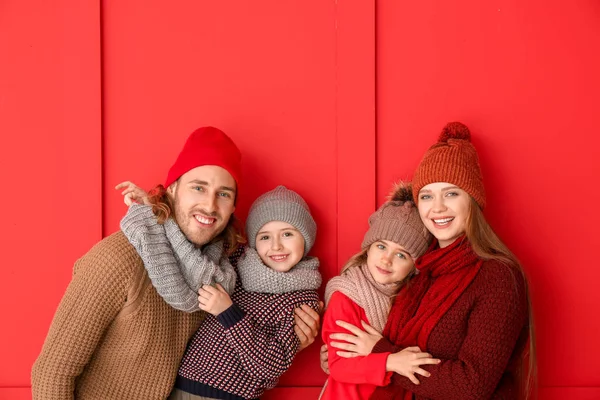 Família feliz em roupas de inverno em fundo de cor — Fotografia de Stock