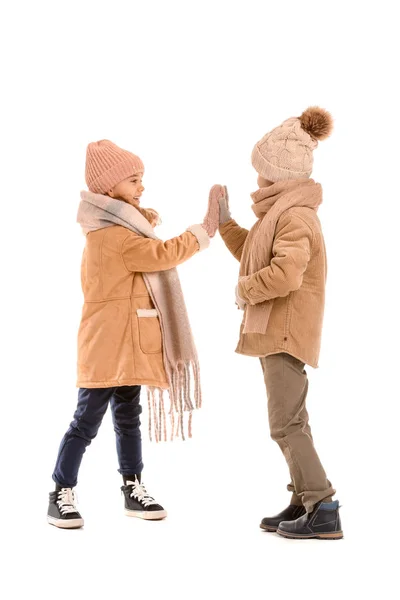 Niños pequeños en ropa de invierno que se dan choca los cinco sobre fondo blanco —  Fotos de Stock