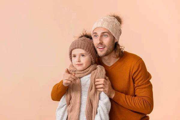 男人和他的儿子穿着彩色背景的冬衣 — 图库照片