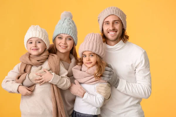 Happy family in winter clothes on color background — Stock Photo, Image
