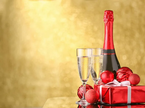 Garrafa, copos de champanhe, presente e decoração de Natal no fundo de cor — Fotografia de Stock