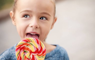 Dışarıda lolipopu olan sevimli küçük bir kız.