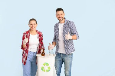 Renkli arka planda çöp konteynırı olan bir çift. Geri dönüşüm kavramı