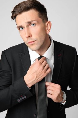 Gri arka planda yakışıklı genç iş adamı