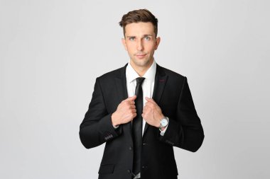 Gri arka planda yakışıklı genç iş adamı