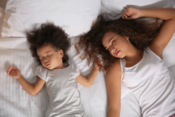 Little African-American girl with mother sleeping in bed at night — Stock Photo, Image