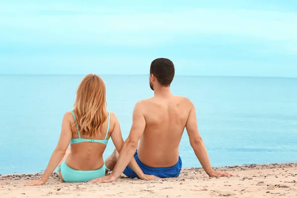 Glückliches Paar sitzt am Strand im Seebad — Stockfoto