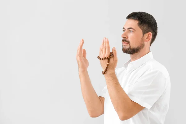 Muslim man praying against light background — Stock Photo, Image