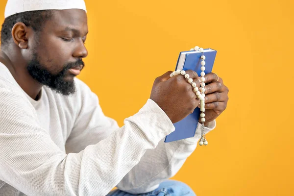 Hombre musulmán afroamericano con Corán y cuentas sobre fondo de color — Foto de Stock