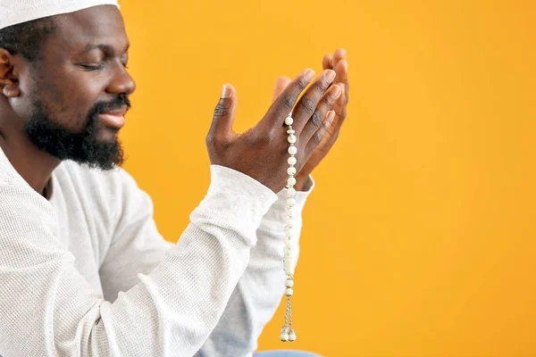 African-American Muslim man praying against color background — Stock Photo, Image