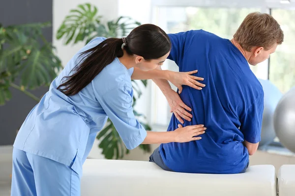 Physiotherapist working with male patient in rehabilitation center — Stock Photo, Image