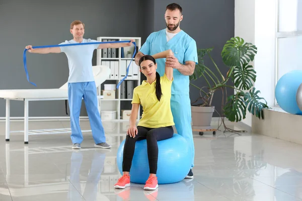 Physiotherapist working with female patient in rehabilitation center — Stock Photo, Image