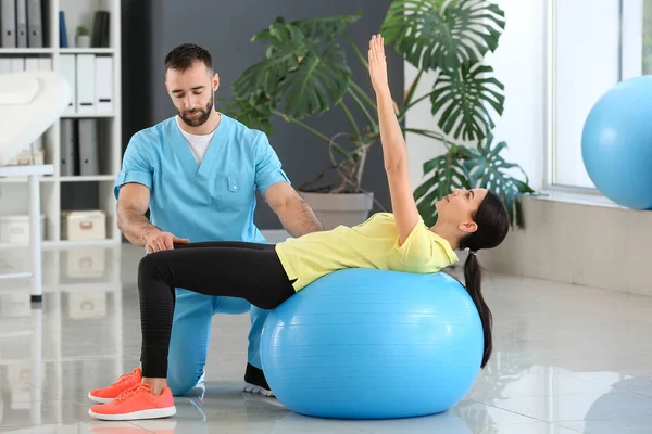 Physiotherapist working with female patient in rehabilitation center — Stock Photo, Image