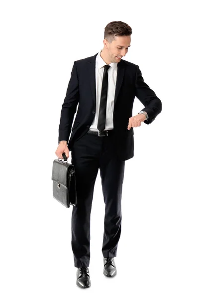 Handsome young businessman looking on his watch against white background — Stock Photo, Image