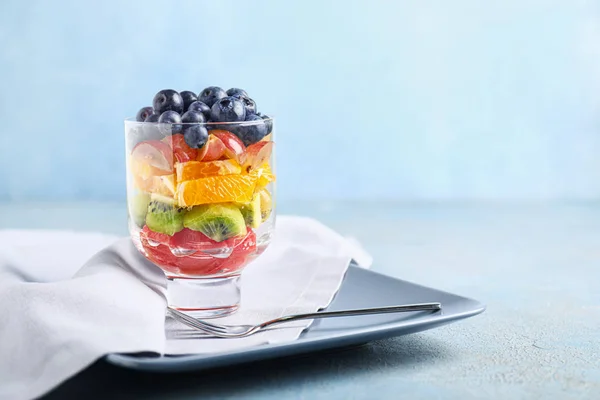 Vidrio con sabrosa ensalada de frutas sobre fondo de color —  Fotos de Stock