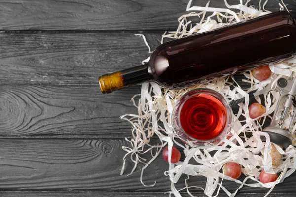 Garrafa e copo de vinho saboroso na mesa de madeira — Fotografia de Stock