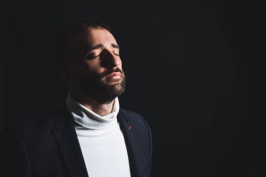 Karanlık arka planda üzgün genç bir adamın portresi