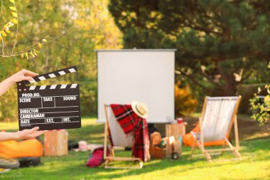 Açık hava sinemasında film alkışlayan kadın.