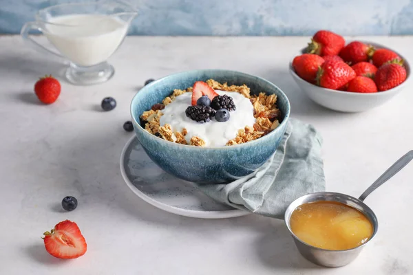 Tasty granola with yogurt in bowl on table — Stock Photo, Image