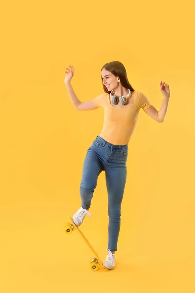 Стильная хипстерша со скейтбордом на цветном фоне — стоковое фото