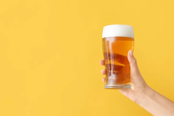 Рука зі склянкою пива на кольоровому фоні — стокове фото