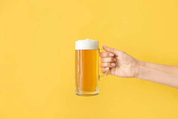 Hand with mug of beer on color background — Stock Photo, Image