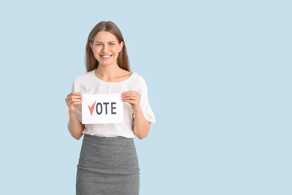 Jovem segurando papel com texto VOTE sobre fundo de cor — Fotografia de Stock