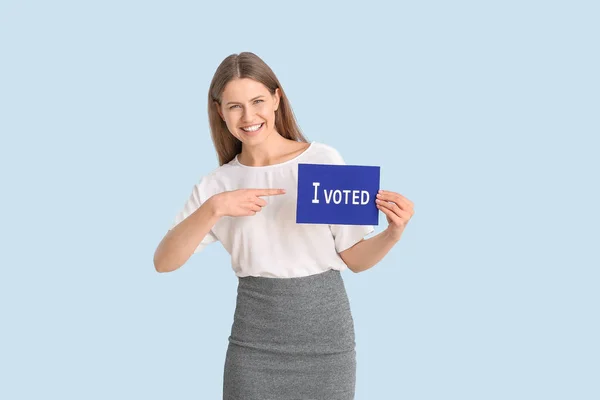 Jovem segurando papel com texto I VOTED em fundo de cor — Fotografia de Stock
