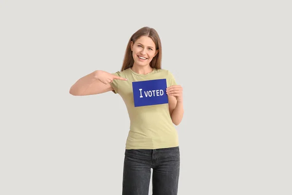 Jovem segurando papel com texto I VOTED em fundo claro — Fotografia de Stock