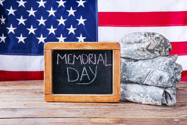 Chalkboard and military uniform on table against USA flag. Memorial Day celebration — Stock Photo, Image