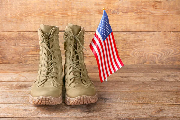 木製の背景に軍用ブーツとアメリカ国旗。記念日 — ストック写真