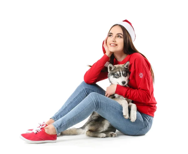 Roztomilá žena v klobouku Santa Claus a legrační husky štěně na bílém pozadí — Stock fotografie