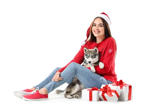 Femme mignonne avec chiot husky drôle et cadeaux de Noël sur fond blanc — Photo