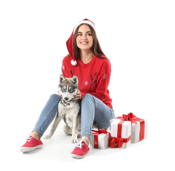 Cute woman with funny husky puppy and Christmas gifts on white background — Stock Photo, Image