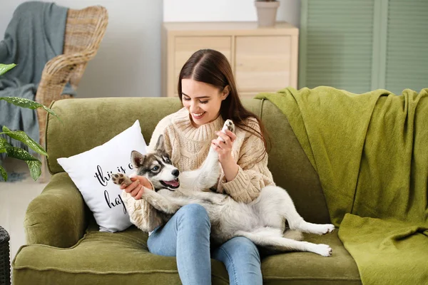 Giovane donna con divertente cucciolo husky riposo a casa — Foto Stock