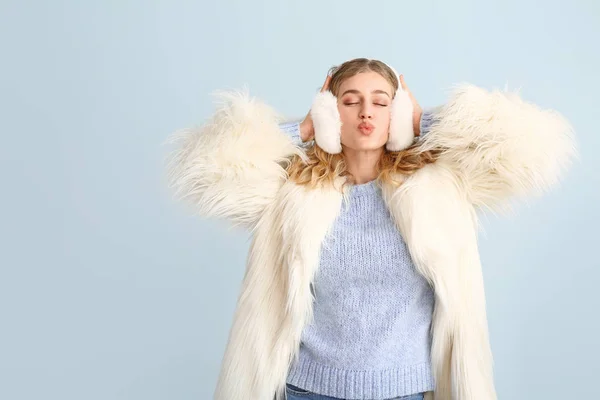 Happy young woman in winter clothes on color background — Stock Photo, Image