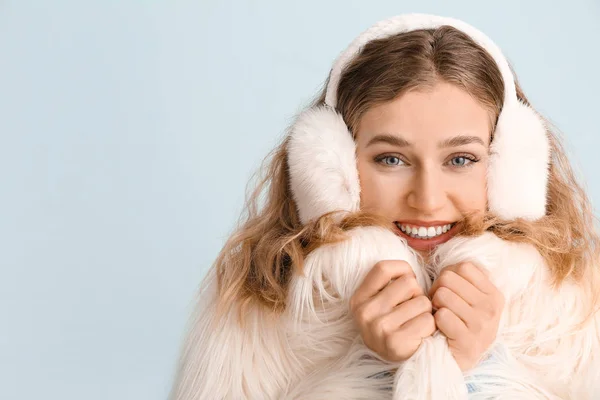 Happy young woman in winter clothes on color background — Stock Photo, Image