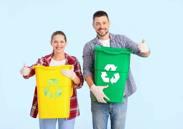 Casal com recipientes para lixo mostrando polegar para cima no fundo de cor. Conceito de reciclagem — Fotografia de Stock