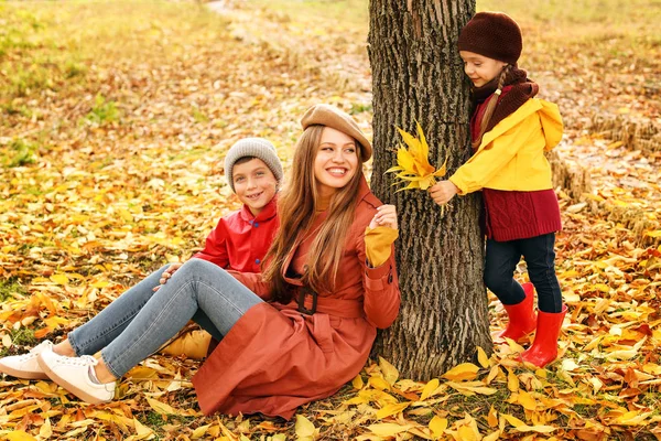 Familia feliz descansando en el parque de otoño —  Fotos de Stock