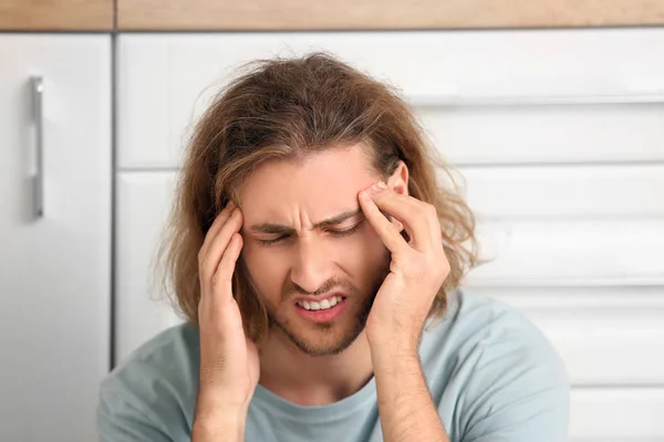 Depressed man in kitchen at home — Stockfoto