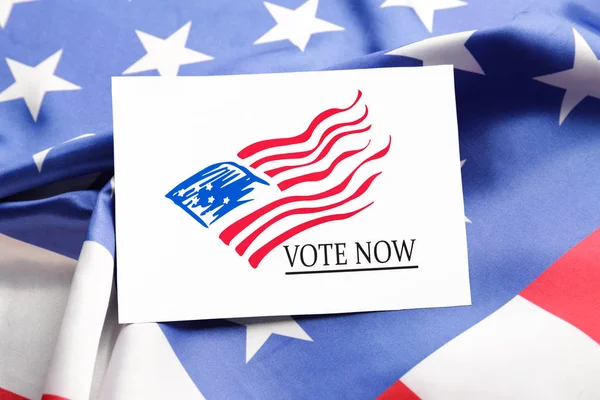 Paper with text VOTE NOW on USA flag — Stockfoto