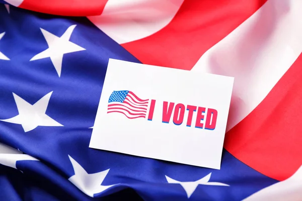 Paper with text I VOTED on USA flag — Stockfoto