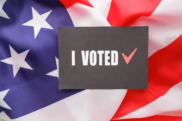 Paper with text I VOTED on USA flag — Stockfoto