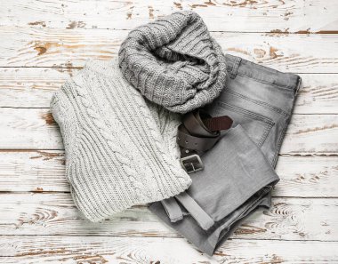 Beyaz ahşap arka planda şık kışlık kıyafetler.