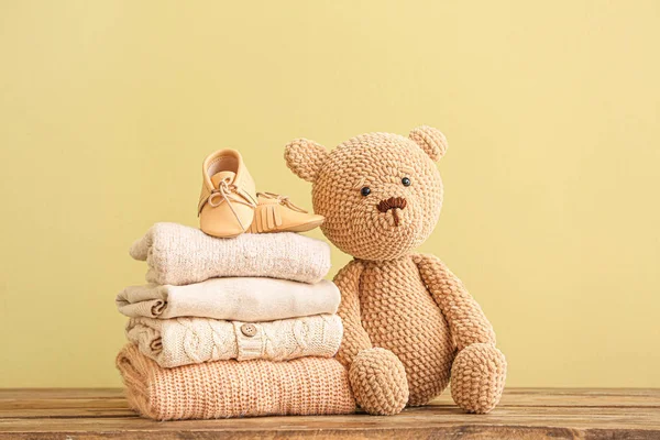 Stack of baby clothes and toy on table — Stock Photo, Image