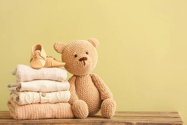 Stack of baby clothes and toy on table — Stock Photo, Image