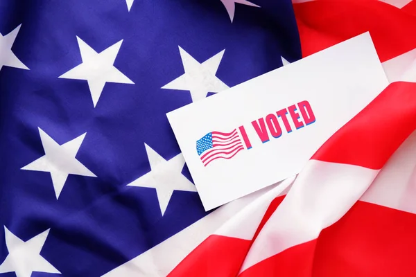 Paper with text I VOTED on USA flag — Stockfoto