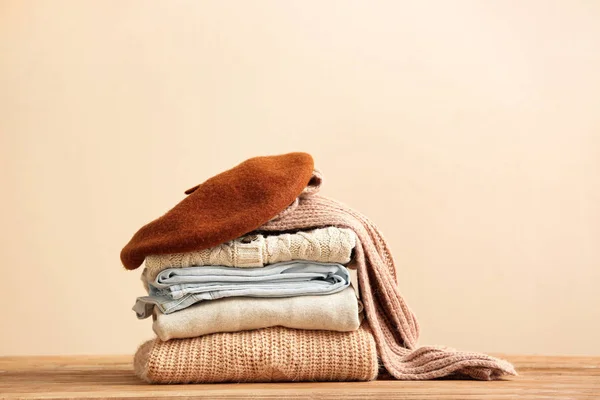 Stack of warm clothes on table — Stockfoto
